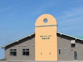 ブラウンの外壁が落ち着いた雰囲気の建物。中央は明るいベージュで住宅の名前が書かれている。