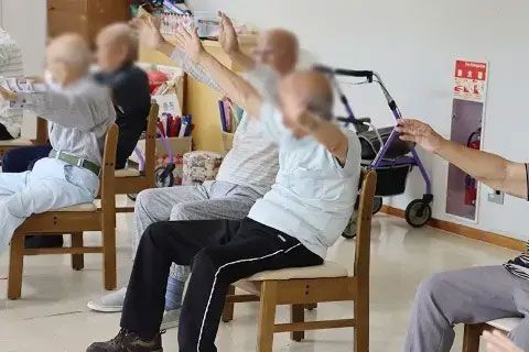 椅子に座って体操する人々