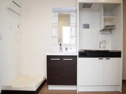オール電化のキッチンと収納付きの洗面所、洗濯機置き場が並んでいる居室の一角。