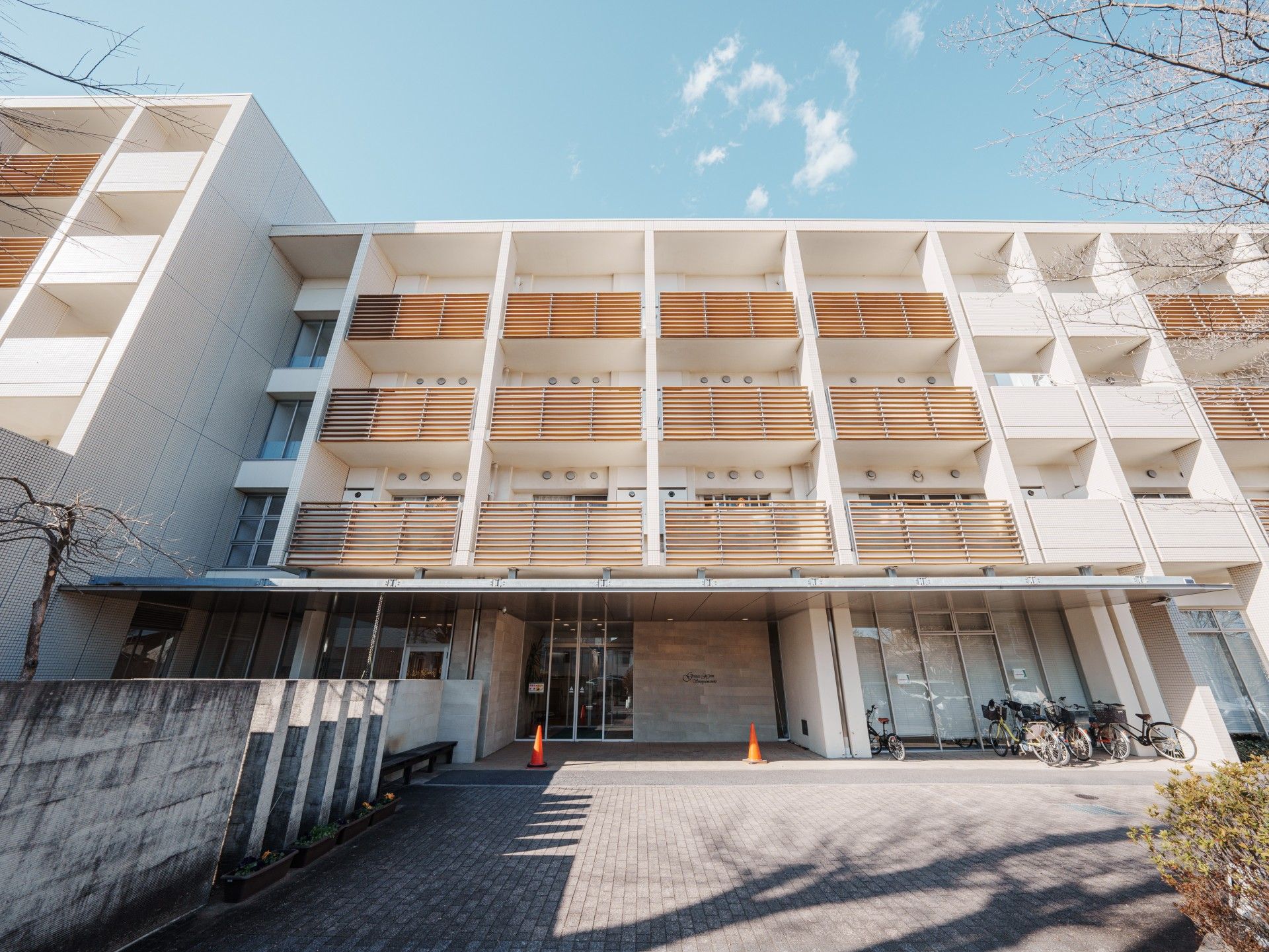 笑顔でこちらを向いている施設のスタッフと車いすに乗っている高齢者の様子。施設で写された写真