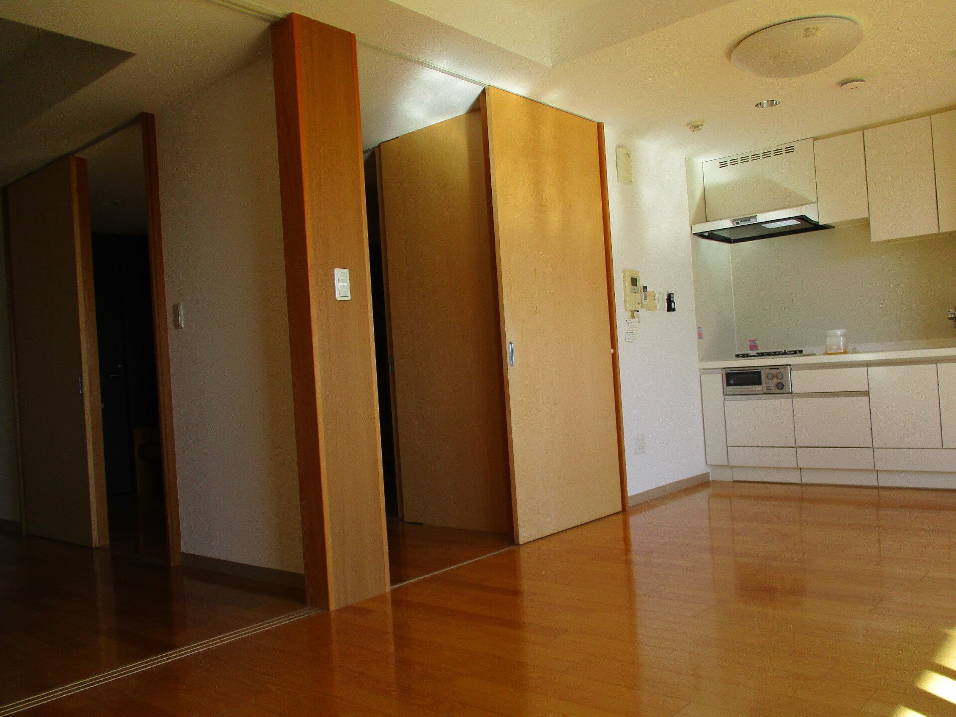 フローリング仕様の居室の様子。奥の方にシステムキッチンが備え付けられている