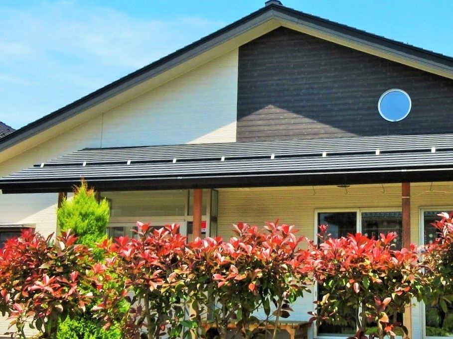 手前に花壇がある平屋建ての建物の外観写真。ツートンカラーのモダンな建物