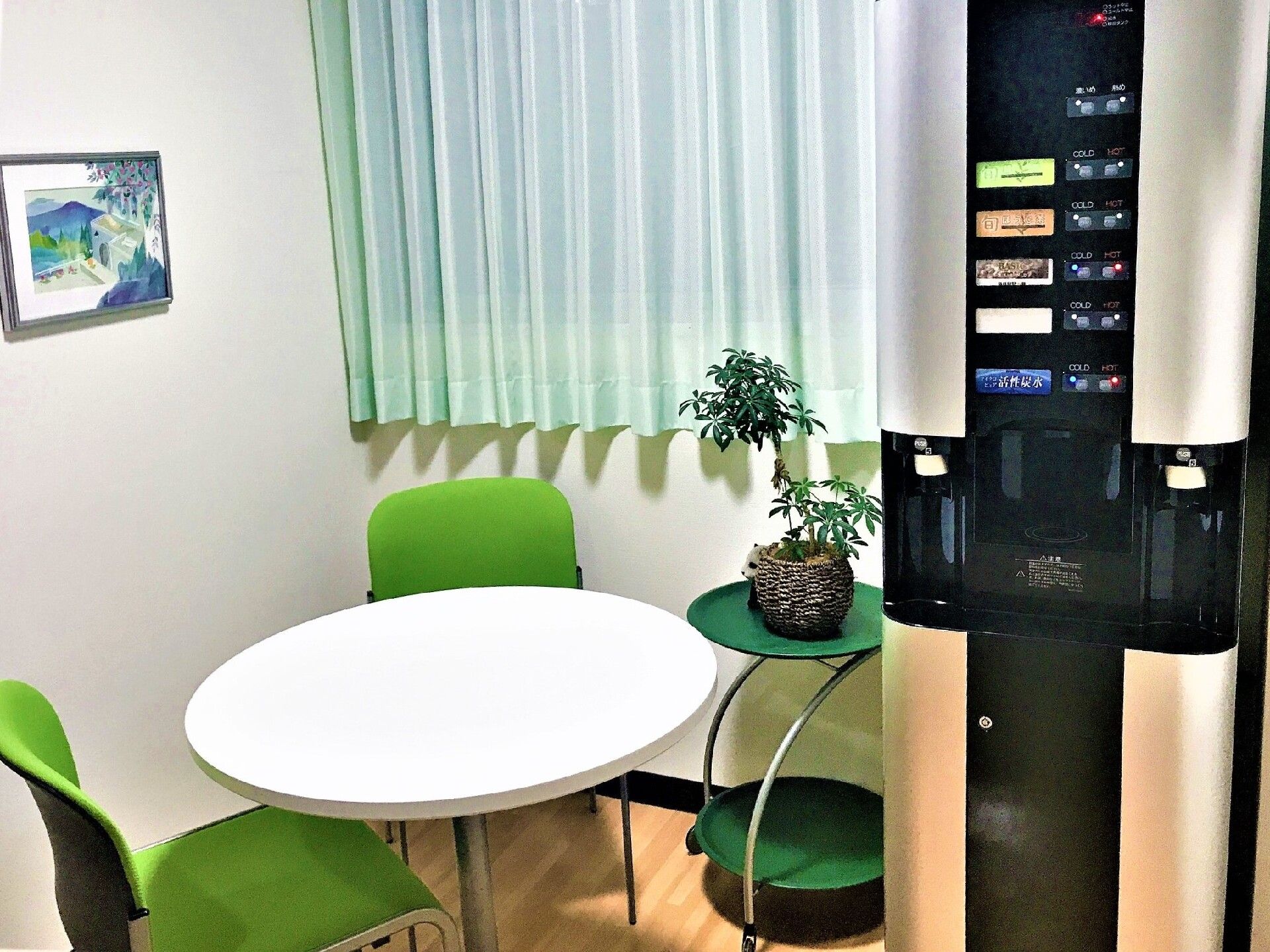 様々なドリンクを楽しむことができる給茶機がセットされたこじんまりとした談話コーナー。観葉植物や絵画が飾られている。