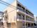 薬局が併設された４階建ての建物。2階部分と3階部分にはベランダが付き、日当たりもよい。周辺にもたくさんの建物が建っている。
