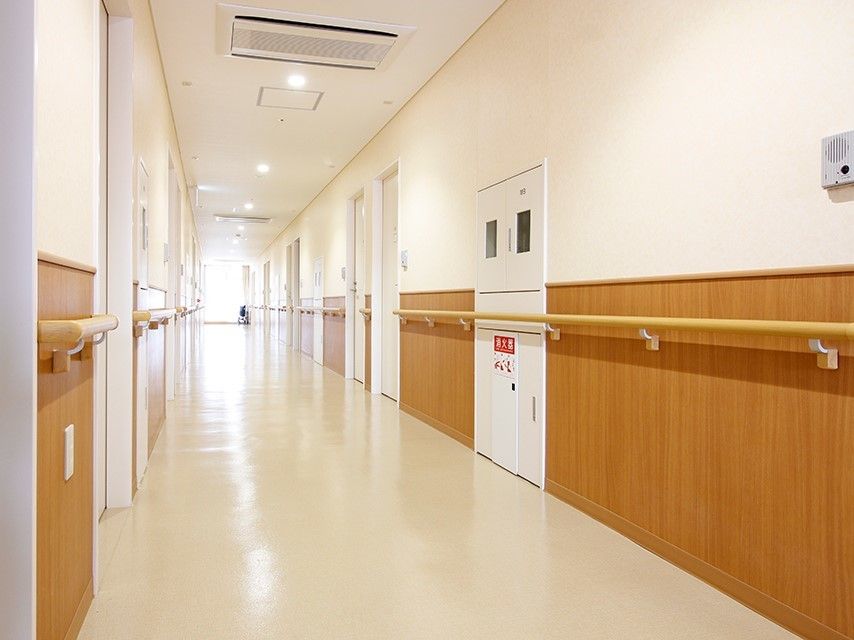 廊下には全域手すりが設置され、まっすぐな廊下にはもの一つ置かれていない。突き当りには窓がある。