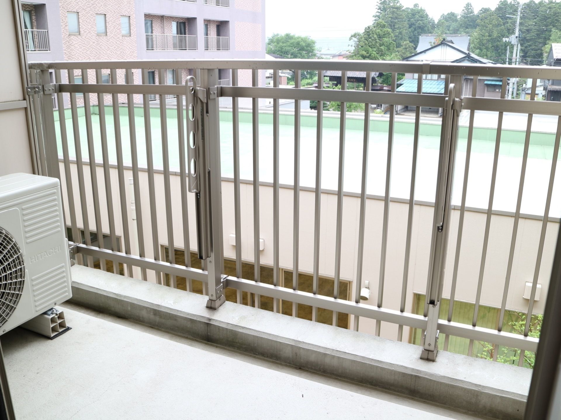 居室に設けられているベランダには、転落防止のフェンスが設置されている。隅には、エアコンの室外機が置かれている。