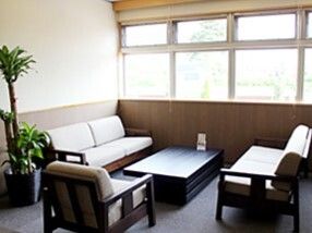 観葉植物が飾られている談話コーナーにはソファの応接セットが置かれ、大きな窓がある。