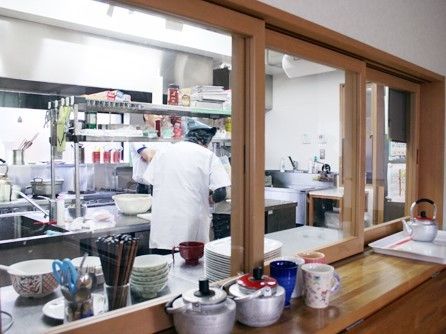 施設内のキッチンで食事を作っている様子。大きめのキッチン風の厨房が写っている写真