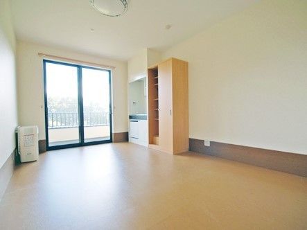 広めのワンルームに収納とエアコン、照明がそろっている。奥のほうにベランダにつながる窓