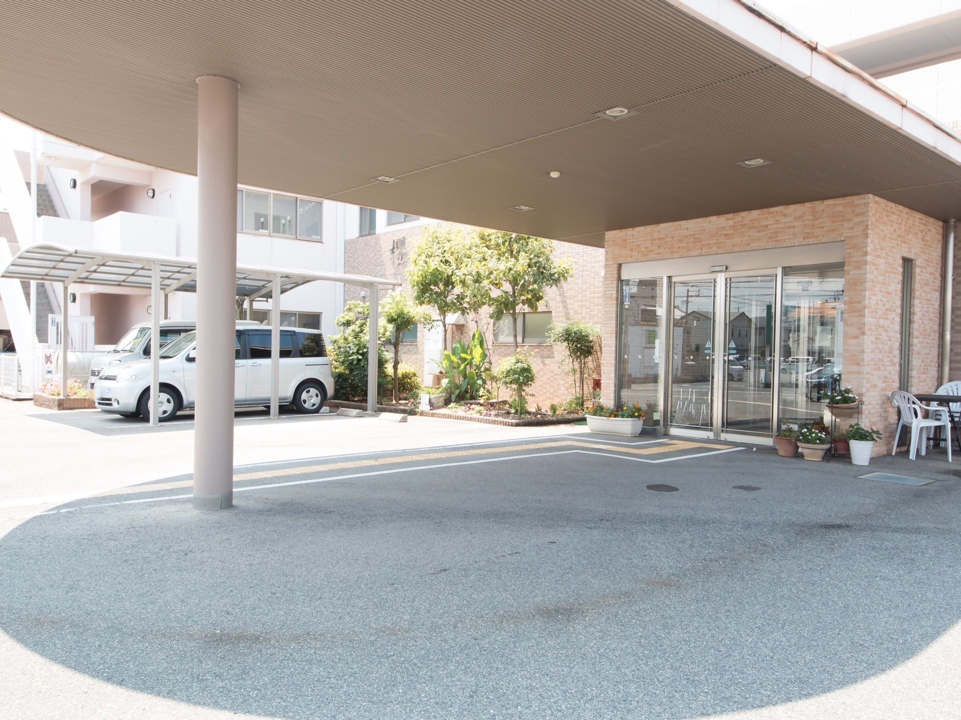 自動ドアを完備している。出入口やまわりに、緑が整備されている。大きな屋根が印象的なエントランスである。