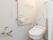 Ｌ字形の手すりが備え付けられた、シンプルなトイレである。洋式の便座を完備している。タオルハンガーもある。