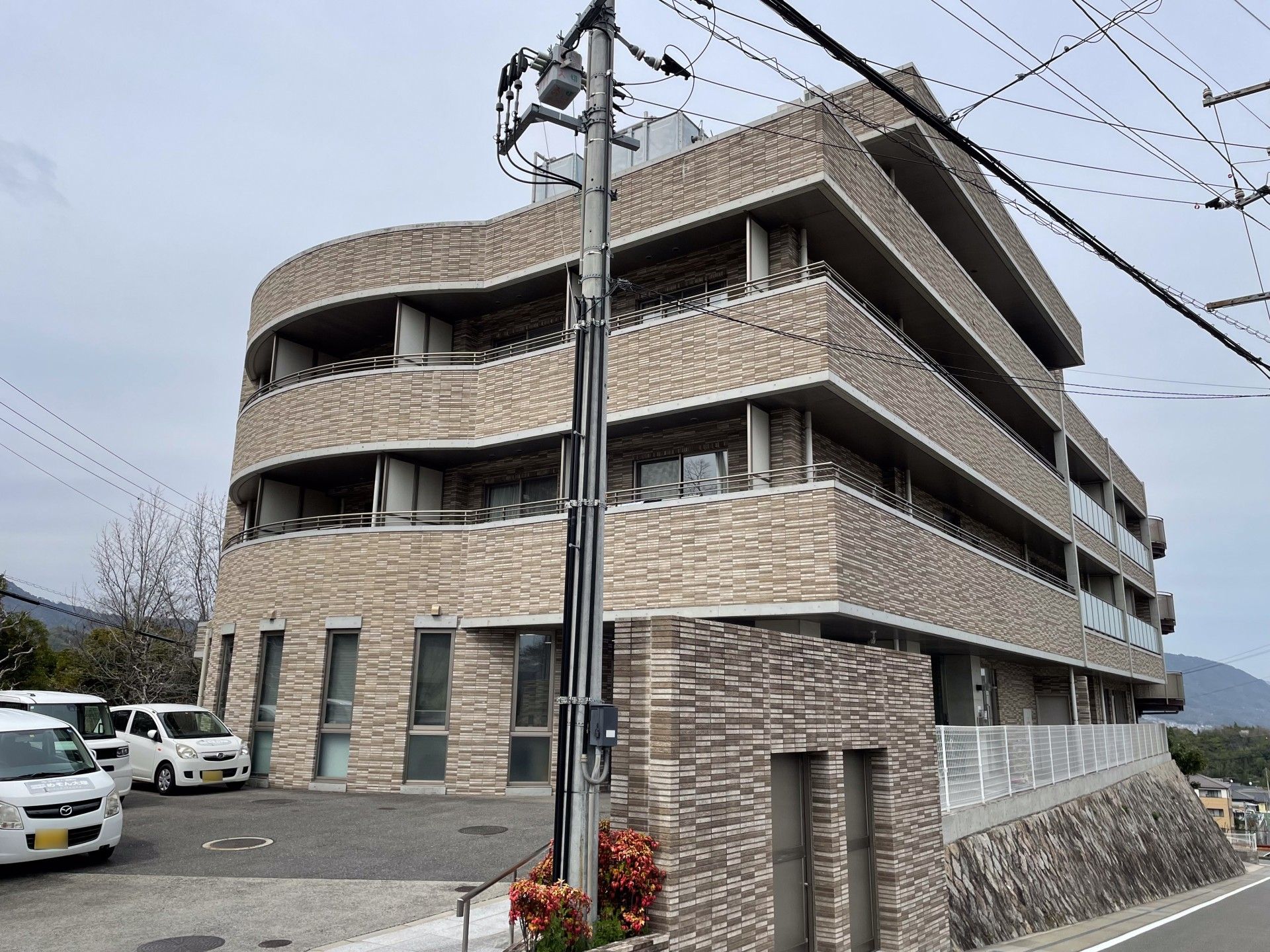 4階建ての建物は日当たりのいい高台に建っている。建物の周りには草木が植えられ明るい雰囲気。