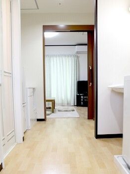 広い居室内には段差がなく、手前には洗面所や浴室があり、奥にはテレビなどがあるリビングスペースがある。