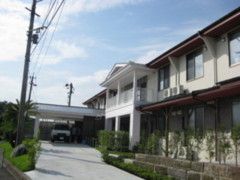 2階建ての建物は木造で温かみのある雰囲気。緑が多く植えられている。