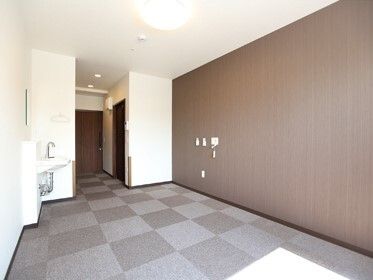 洗面所が設置された部屋にはグレーのカーペットが敷かれ、壁には緊急通報装置が設置されている。