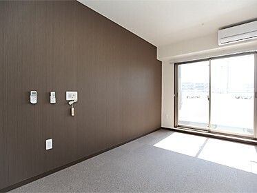 緊急通報装置が設置されている壁にはエアコンや照明のリモコンも設置され、室内にはエアコンも付いている。