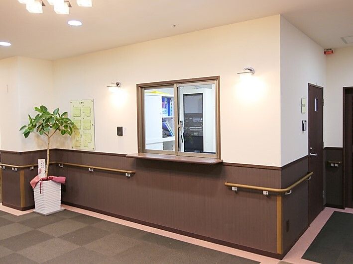 グレーのカーペットが敷かれた館内には手すりも設置されていて、管理室のそばには観葉植物も置かれている。