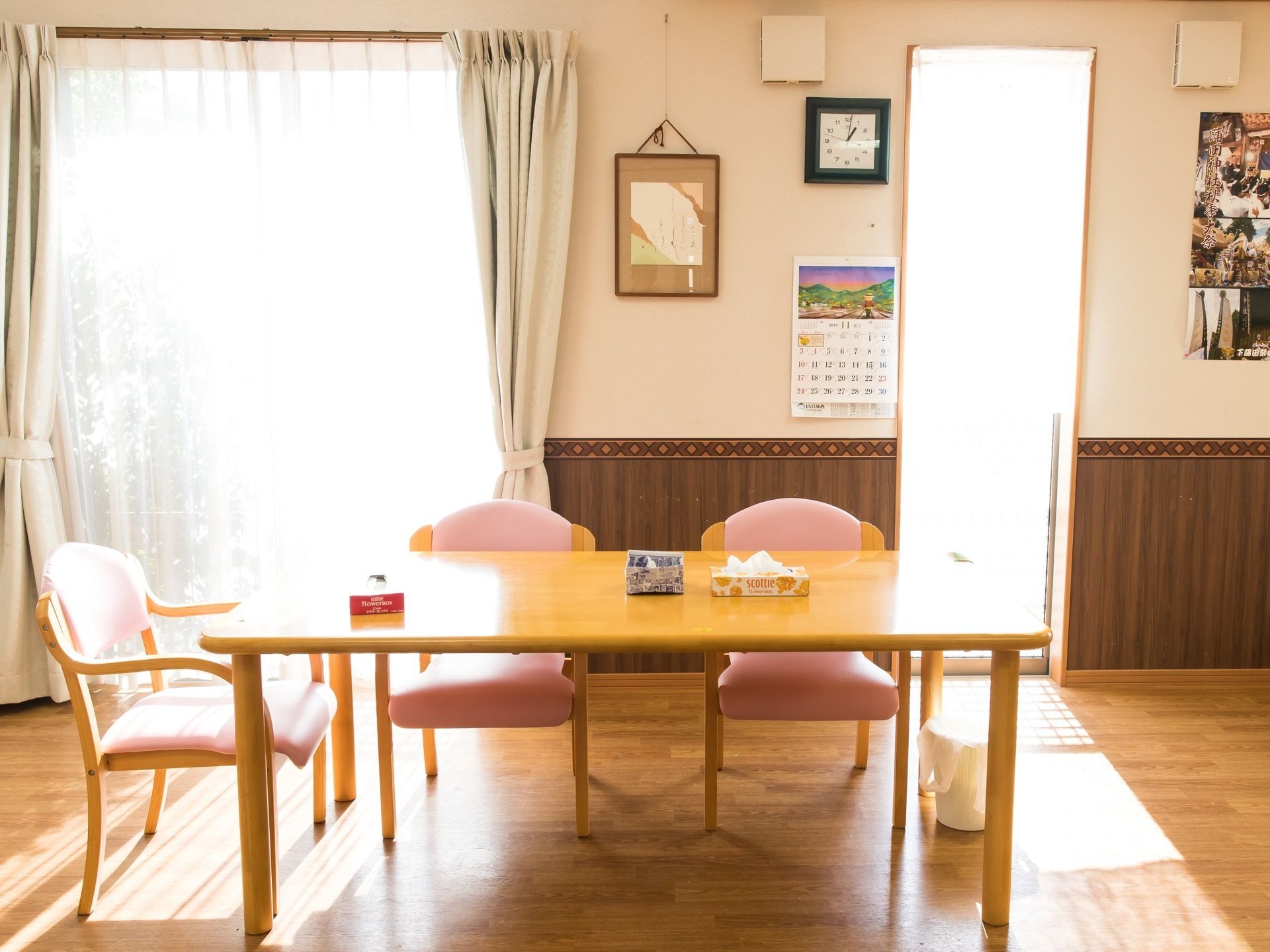 高さのある窓から日差しが差し込んでいる明るい食堂である。テーブルの中央部に、ティッシュペーパーの箱と紙で作られたくずかごが置かれている。