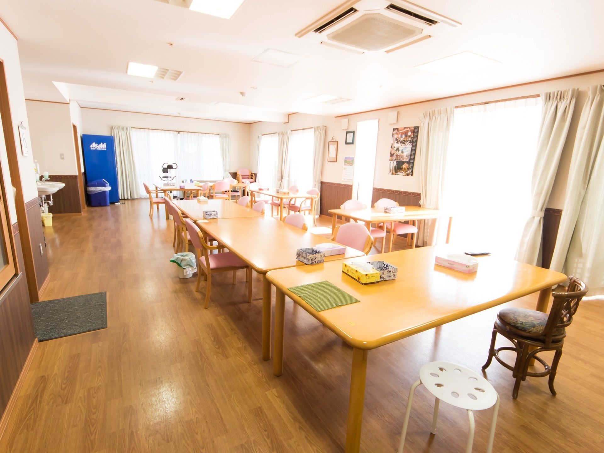 多くのテーブルや椅子が配置された食堂である。窓際に飲料の自動販売機が設置され、その近くに専用のごみ箱が置かれている。
