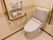トイレにふたつき便座が設置されている。トイレットペーパーホルダーを取り囲むようにして、大きなＬ字型の手すりが取り付けられている。