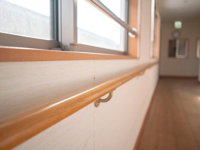 丸みを帯びた手すりが付いている廊下はまっすぐで幅が広い。窓が左側についている。