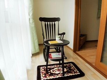 大きな窓にはカーテンが付いていて、居室のリビング部分との間にはドアが設置され、サンルームとなっている。テーブルセットが置かれている。