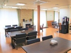 ゆったりと座れる大き目の椅子がセットされたダイニングテーブルが並んだ食堂には暖炉スペースやコーヒーマシンもある。