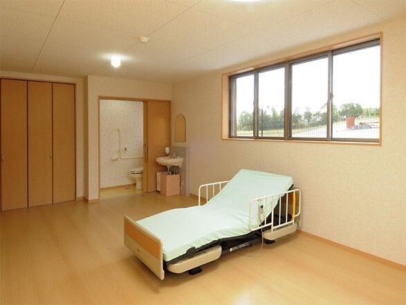 ベッドが置いてある広めの居室。収納やトイレがある部屋の中の様子