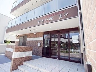 前を指差す高齢女性と後ろで見守る女性ヘルパー