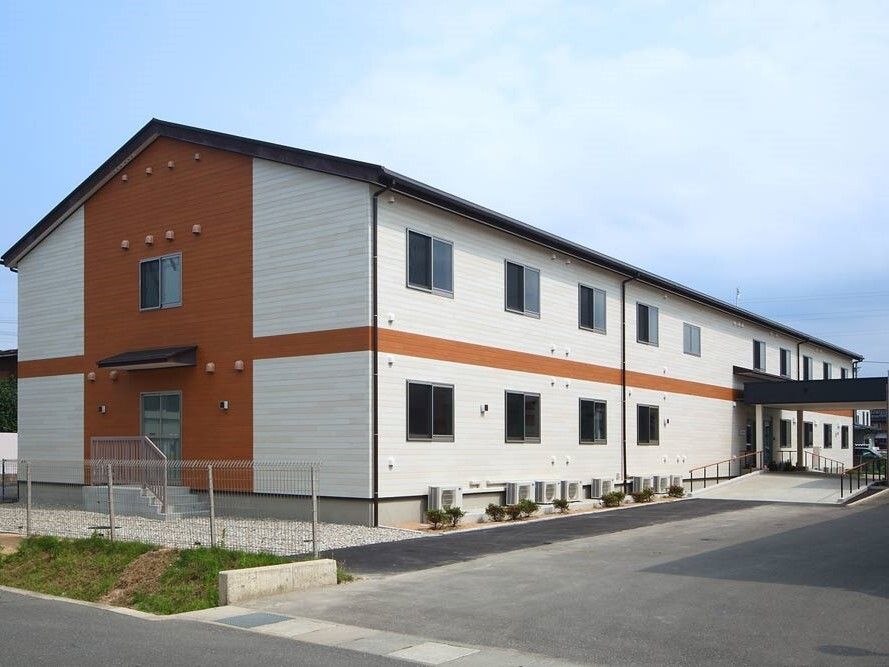 白を基調とした外壁の２階建ての建物は日当たり良好で玄関には緩やかなスロープが付いている。