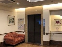 エレベーターが設置された館内。エレベーターホールには赤いソファも置かれている。