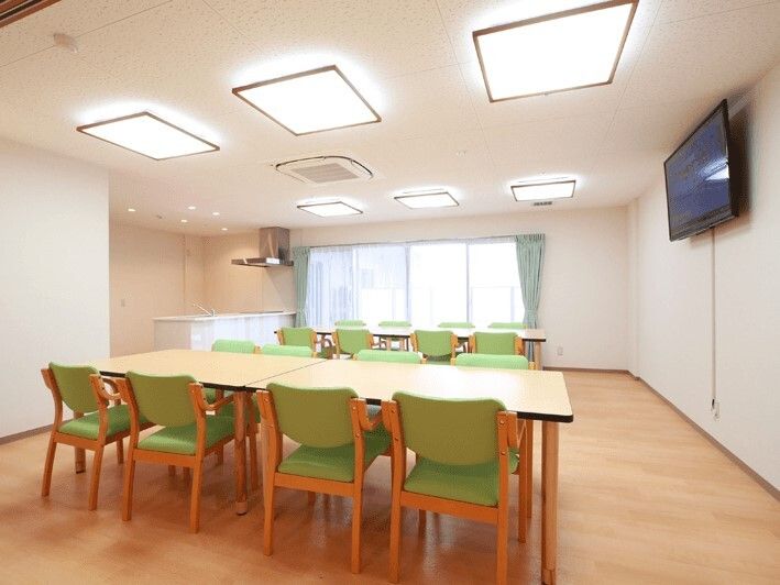 大きな壁掛けテレビが付いた部屋にはダイニングテーブルが二組置かれ、それぞれに8名座ることができる。奥にはキッチンも付いている。