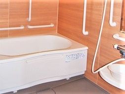 手すりが多く設置された浴室。浴槽の横にはシャワーがある。