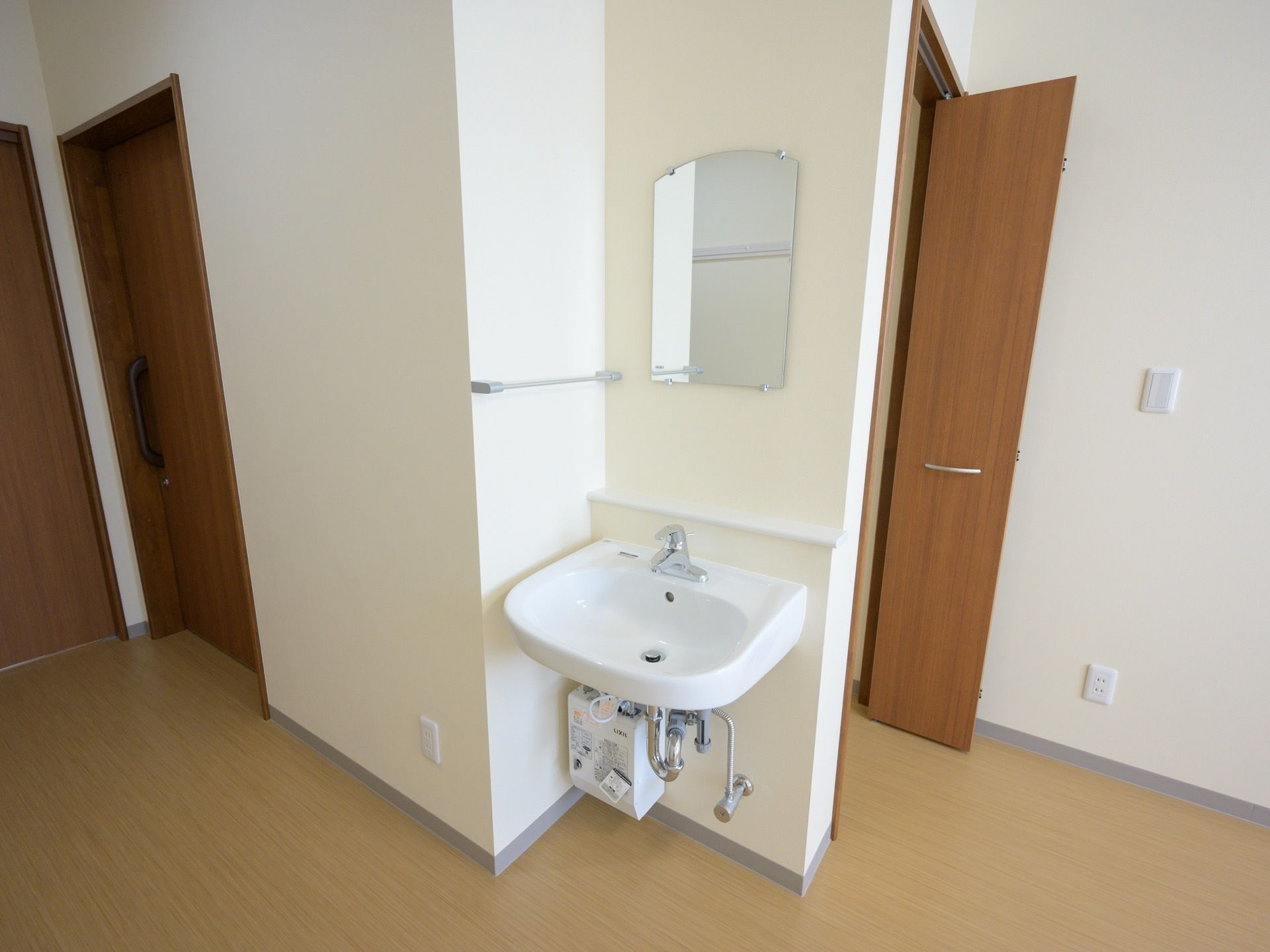 居室の一角に洗面台がある。足元は配管と湯沸かし器があり、車椅子でも使いやすい形になっている。
