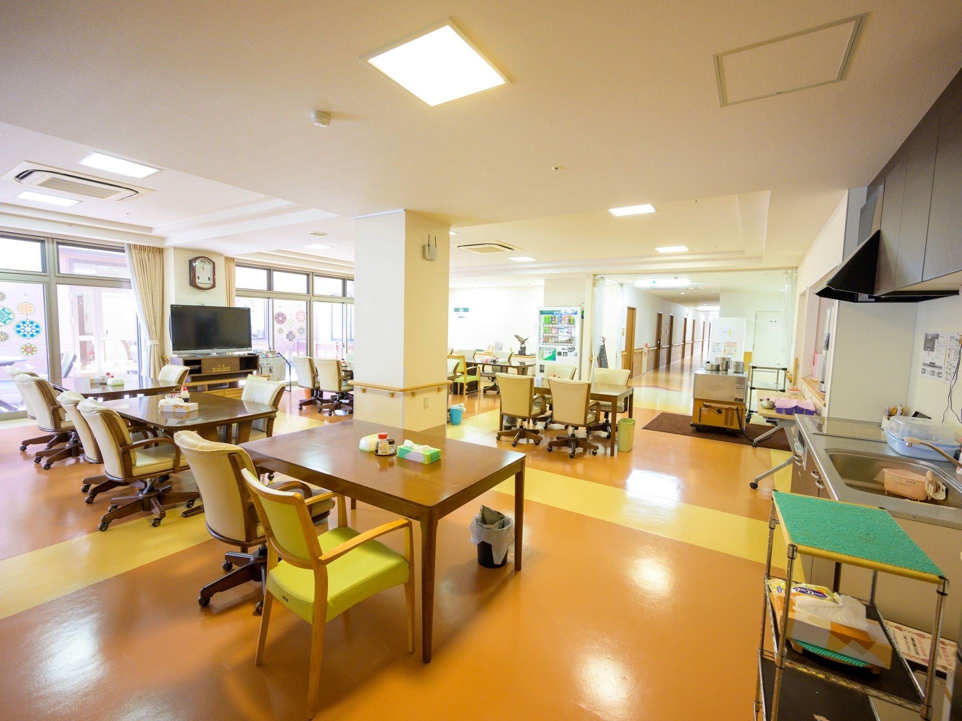 居室を出て廊下を進むと明るい食堂がある。テーブルセットが並べられ、窓際には大型テレビがある。