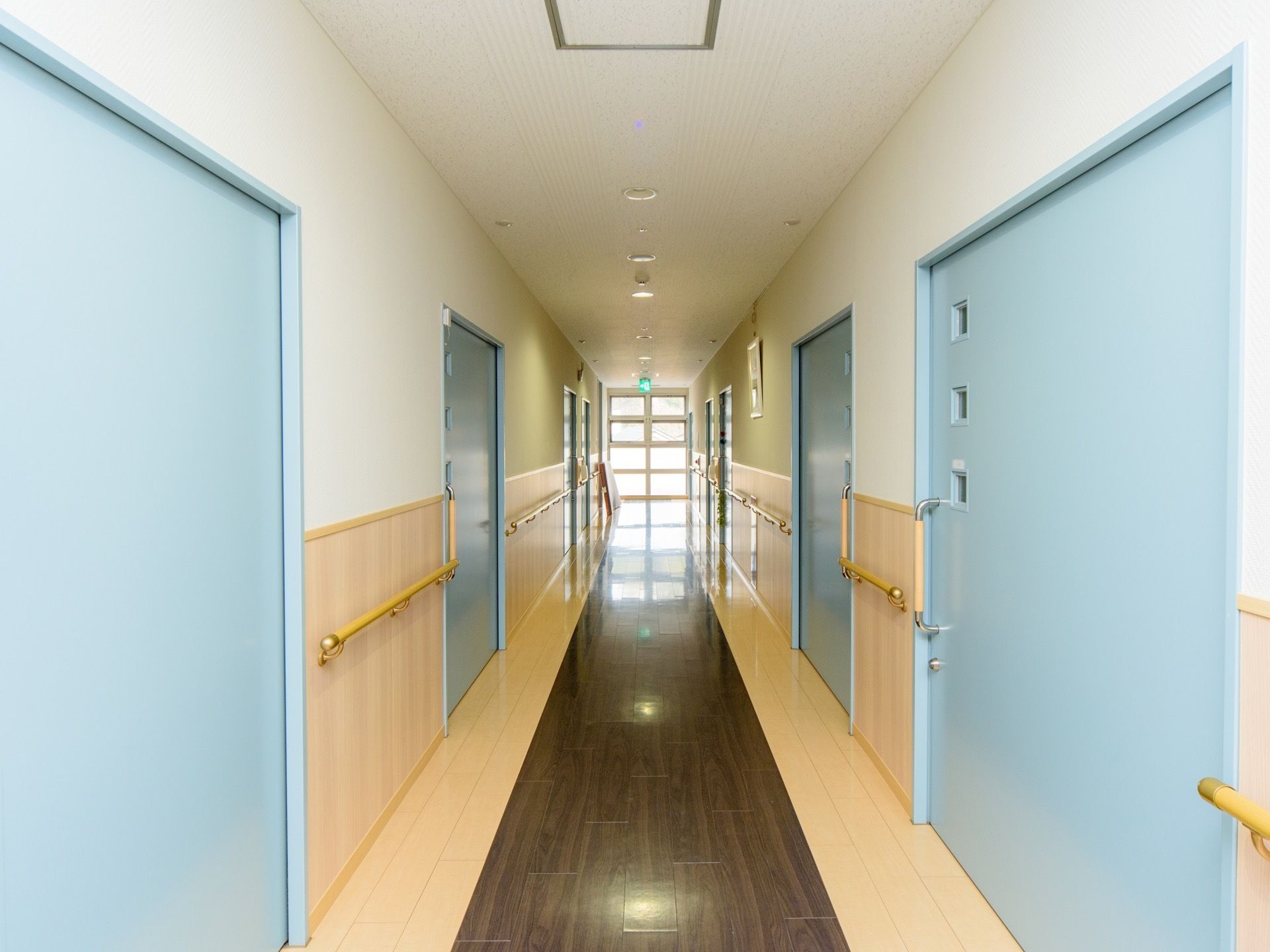 居室のドアは、水色に色塗られており、小さな小窓が3つ付いている。その下には、大きなI字型の手すりとともに鍵がある。