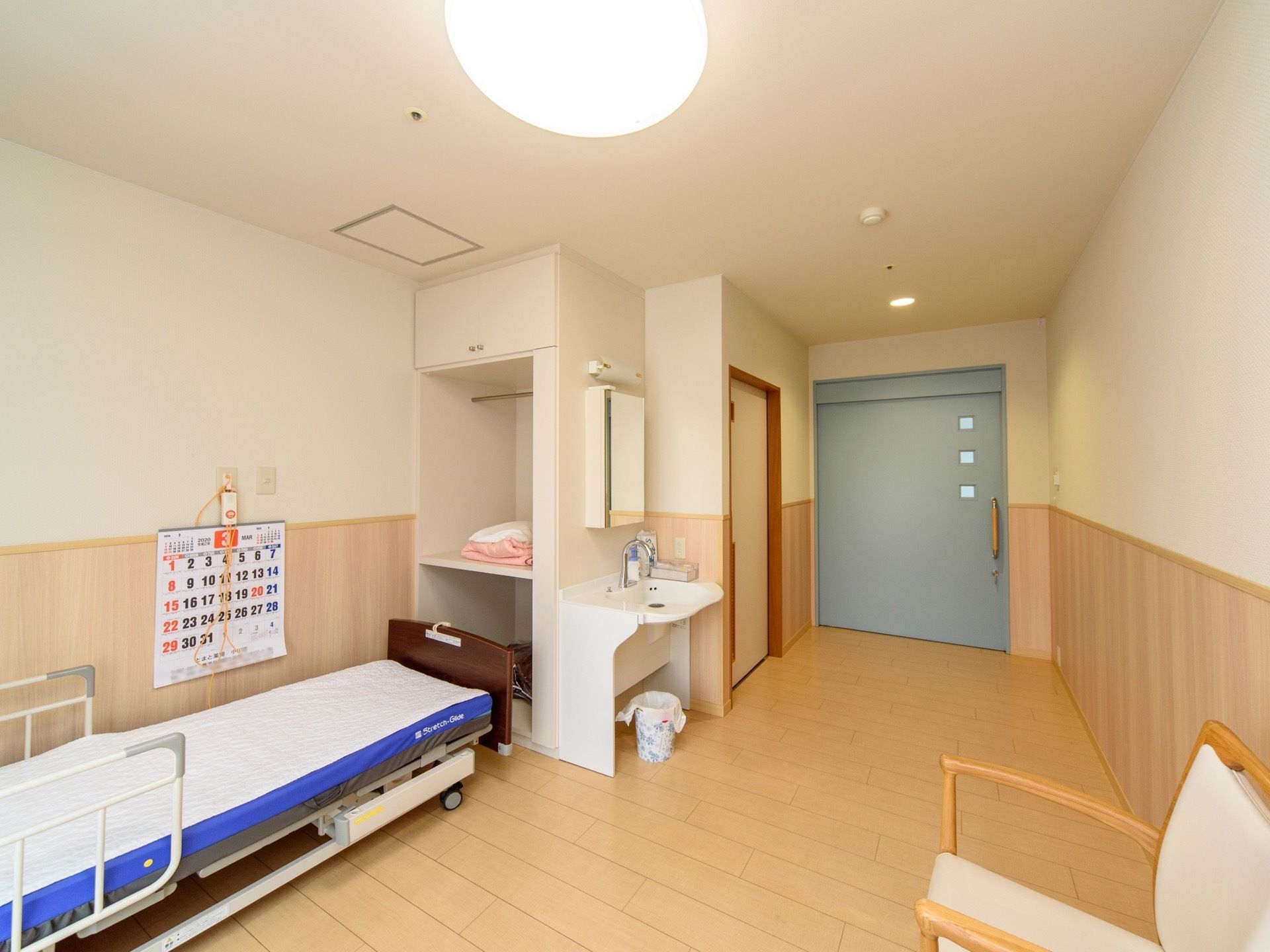 居室のドアは濃い青色で、横に大きく開くことができる。ベッドの側にある棚の裏には、洗面台が設置されている。