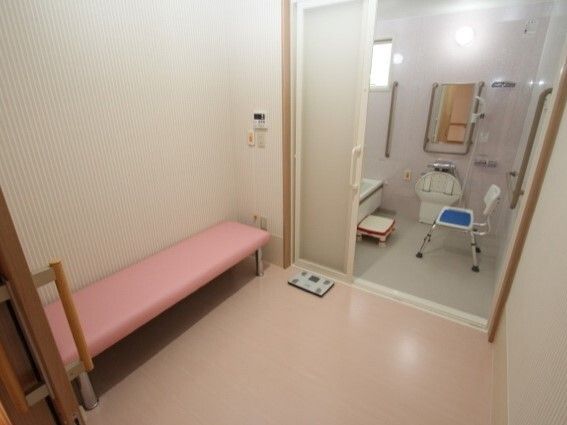 呼び出しボタンが設置された脱衣所には体重計とベンチ型の椅子があり、浴室のドアはワイドタイプで、浴室内にはシャワーチェアもある。