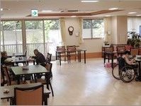 広めのスペースにたくさんのテーブルと椅子が並べられている施設内の食堂の様子