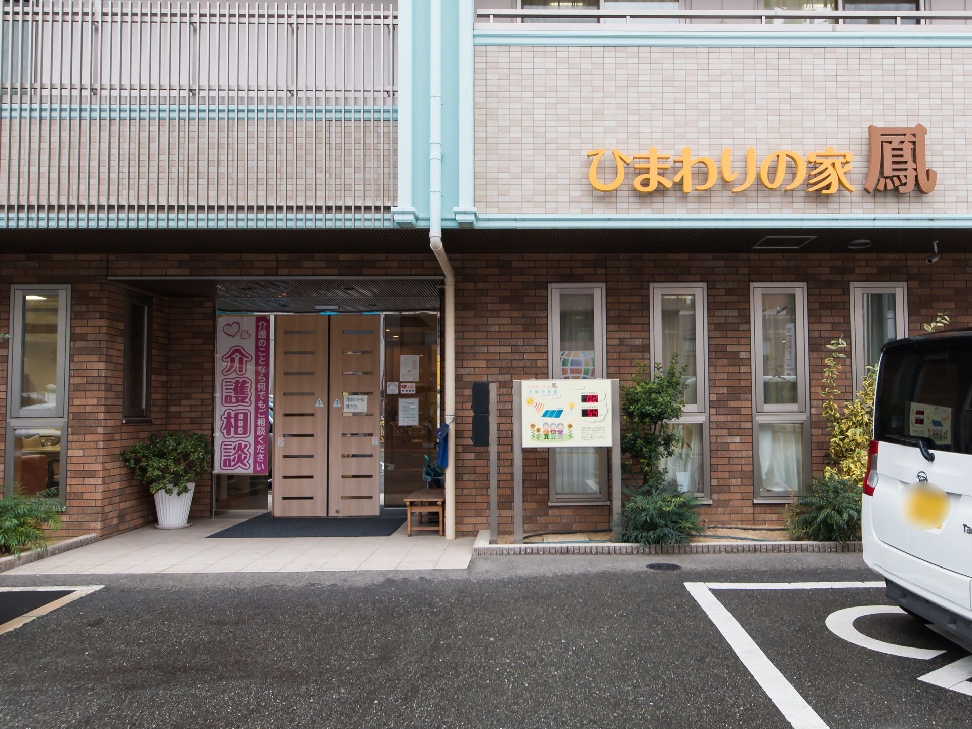 玄関は、横方向のスリットガラスが左右に９枚ずつ入った両開きの自動扉である。ドアの右側に木製のベンチが置かれている。