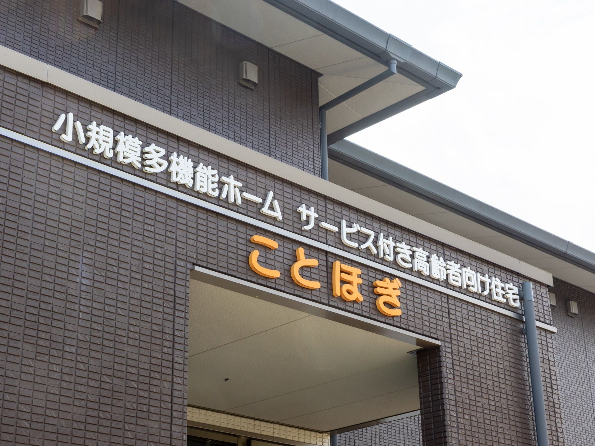 外壁が茶色いタイル張りの２階建て施設である。玄関ポーチ上部の壁面に白と黄色の文字で大きく施設名が記されている。