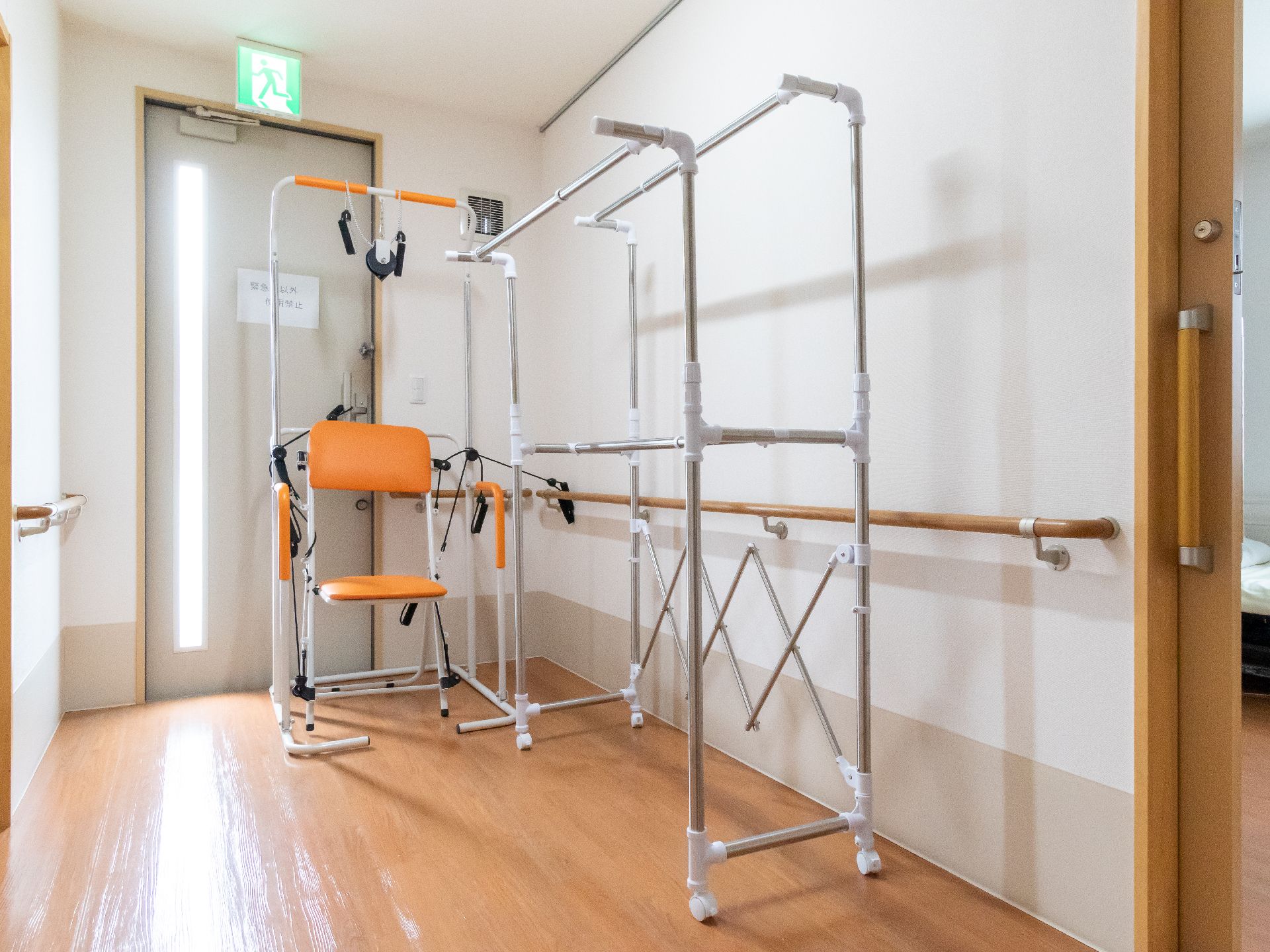 手すりのある廊下の隅に置かれている、室内干しと運動器具