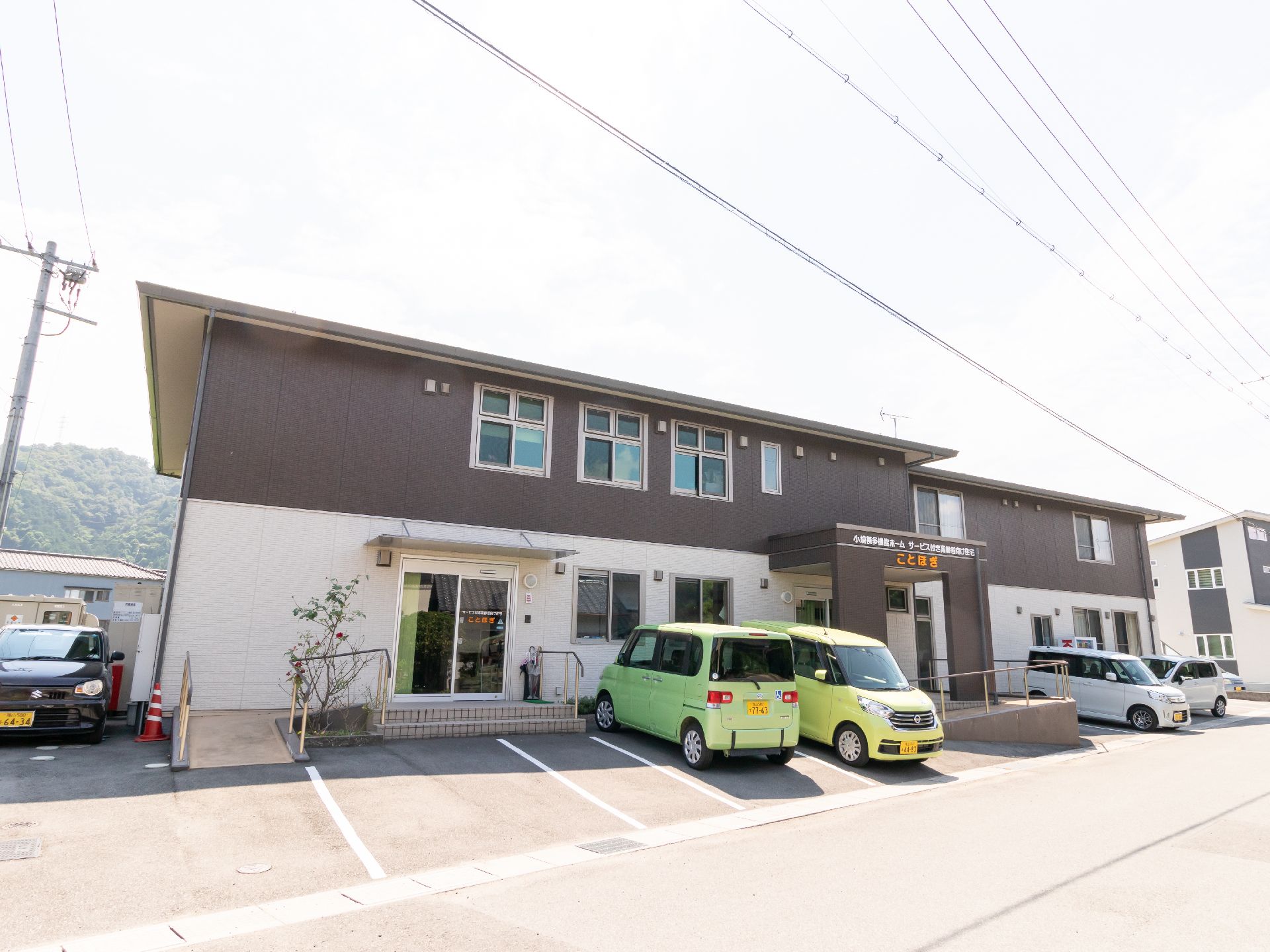 駐車場とスロープがある、上下で外壁の色が異なる建物