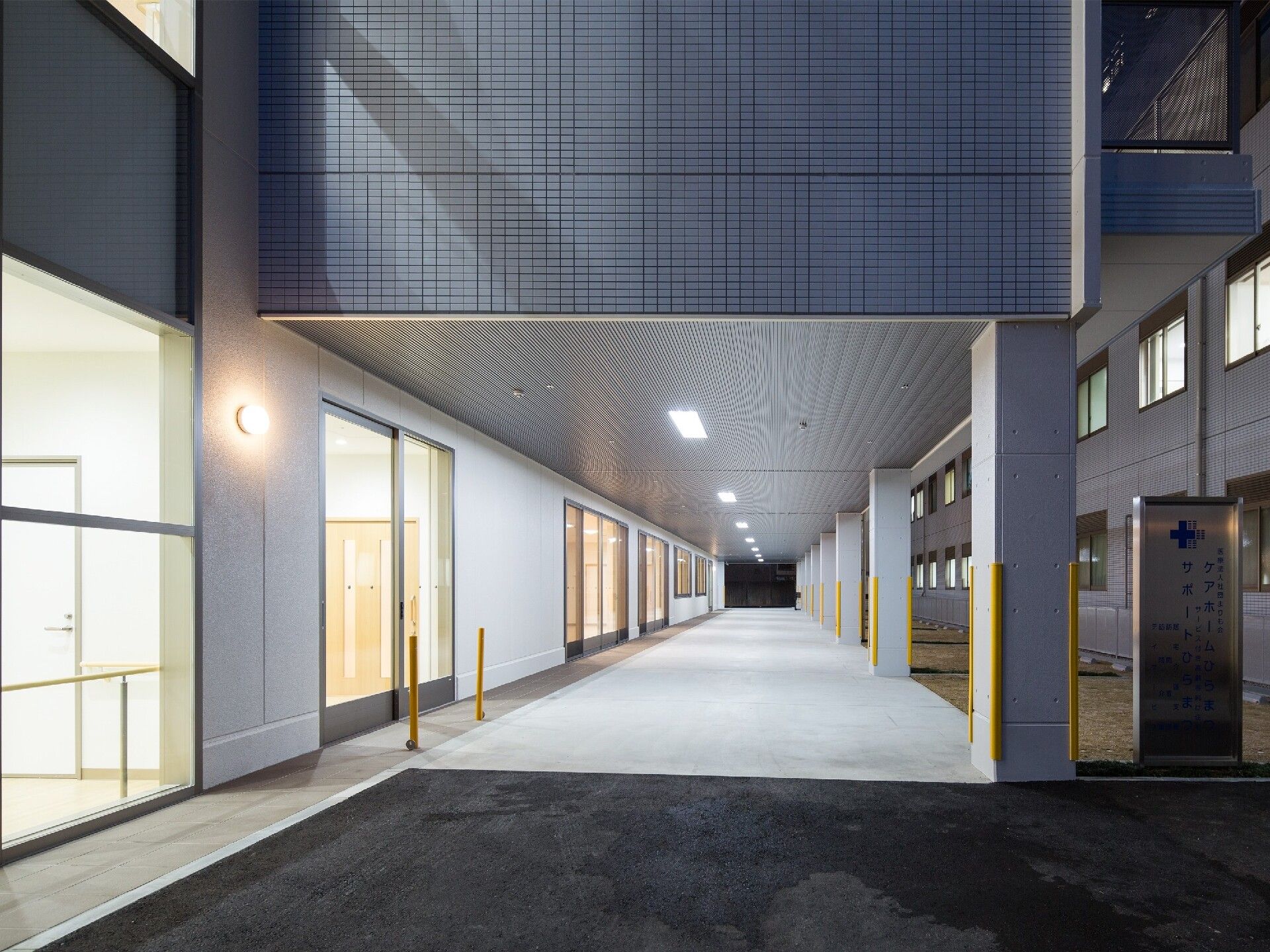 両サイドにライトグレー系の建物があり、中央には屋根が付いたまっすぐな通路がある。