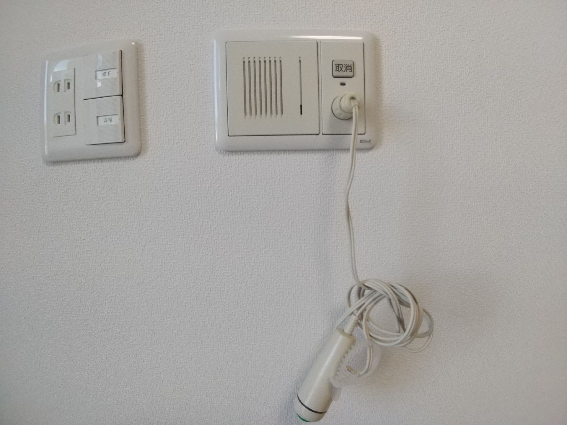 通話ができるタイプの緊急通報装置が設置された壁。緊急通報装置のコードはまとめられている。