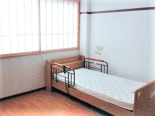 ベッドが置かれたシンプルな居室には窓に障子も付いている。