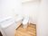 白く清潔感あるトイレには、温水洗浄便座器や手洗い場が完備されている。壁には、手すりがある。