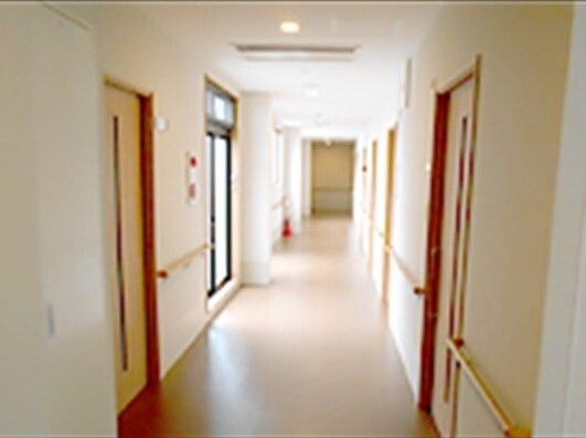 消火器や防災設備も設置されている館内。廊下の両サイドに手すりや居室のドアがあり、窓も付いている。