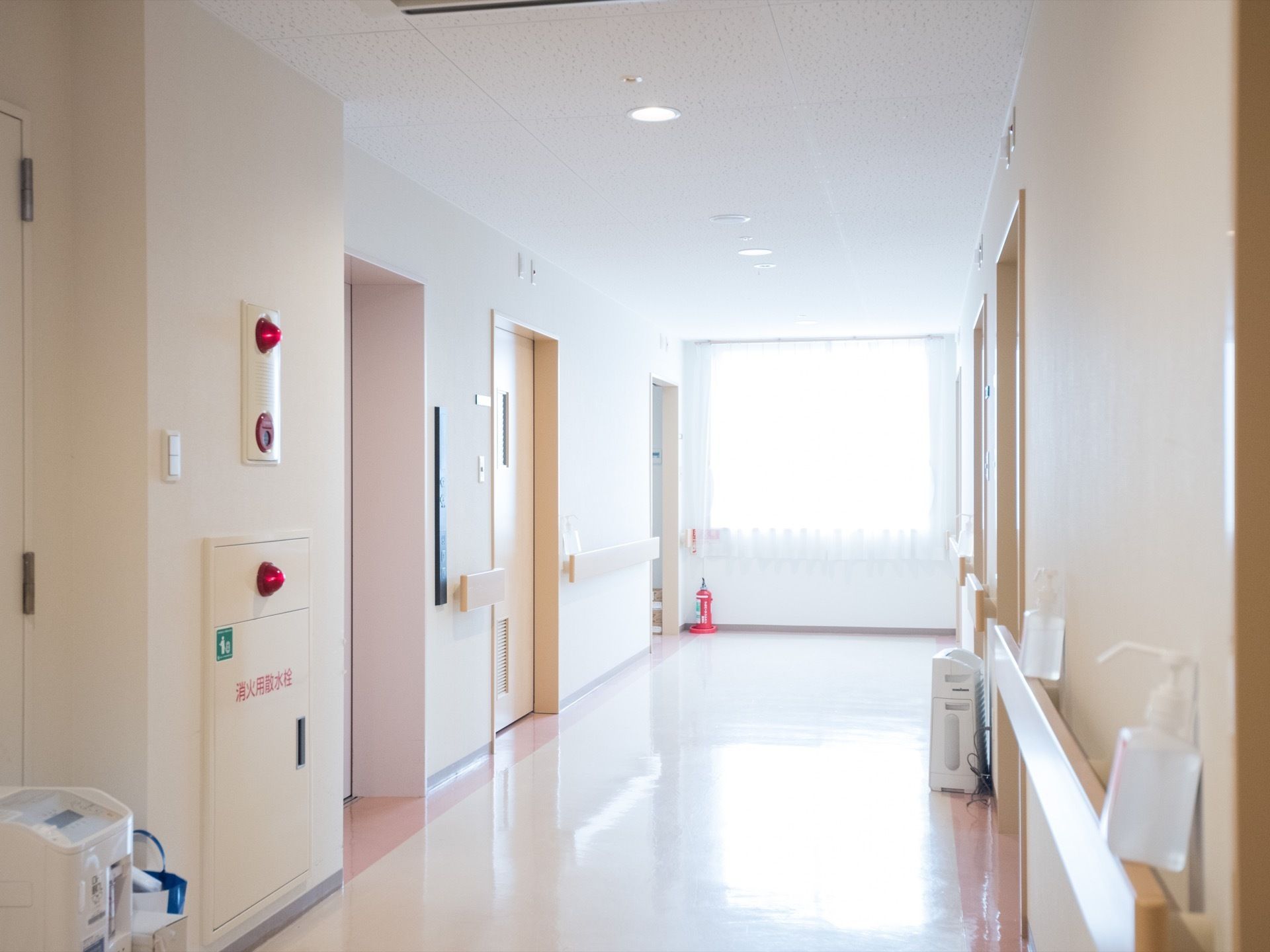 明るく開放的な廊下で、ゆったり行き来することができる。手すりの上には消毒液がいくつも用意されている。