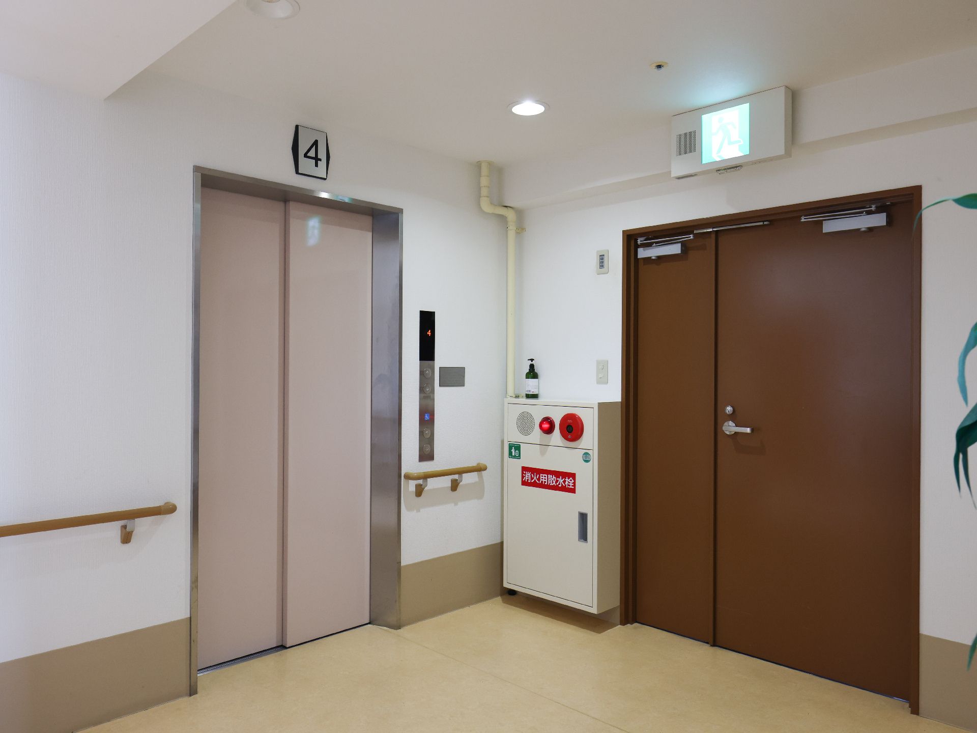 カメラに向かって笑顔を見せるスタッフと高齢者の女性。施設での何気ない一場面の様子